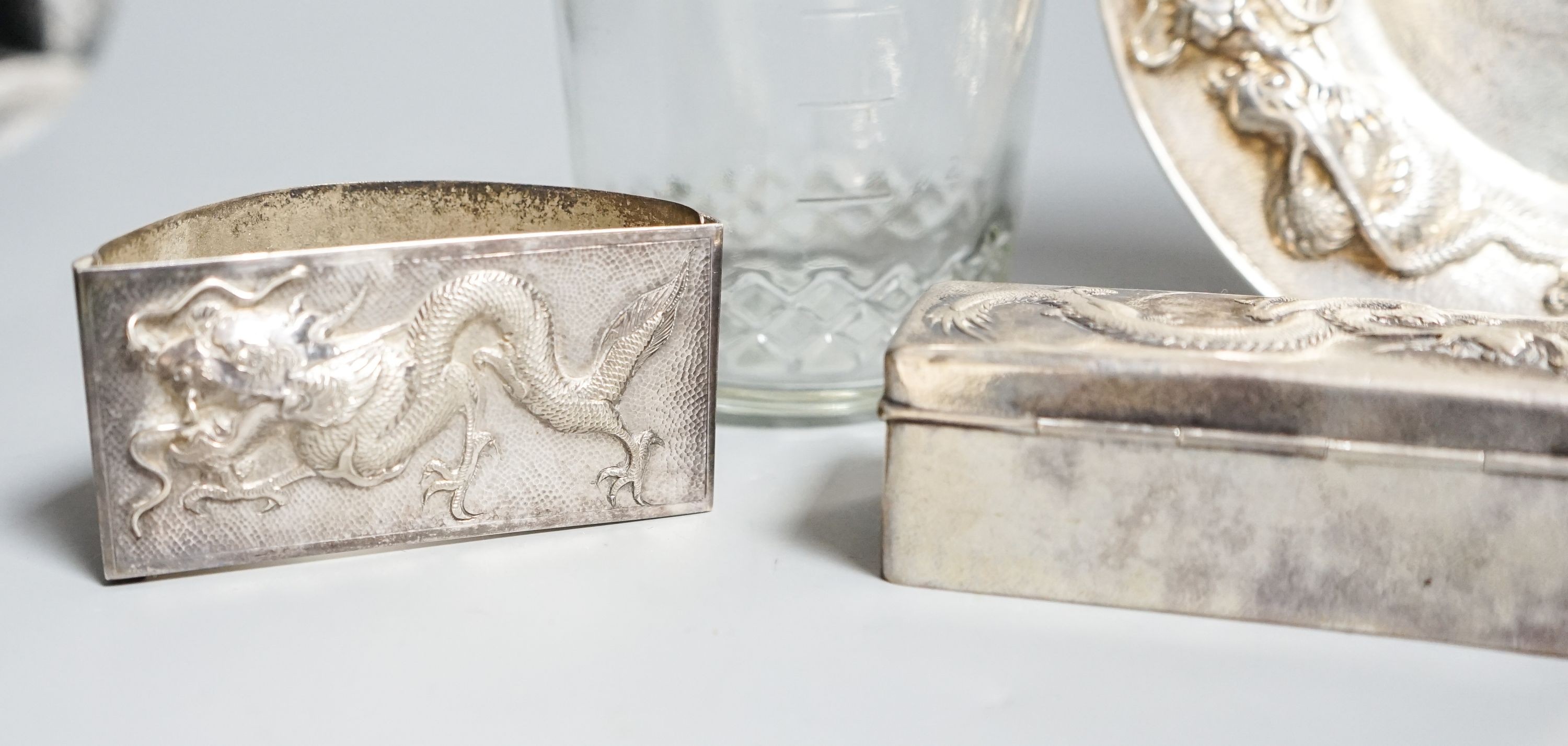 A Chinese white metal dish by Wang Hing, 18.4cm and a similar rectangular box, a white metal mounted jar by Tack Hing and an unmarked blotter.